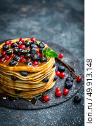 Pancakes with fresh berries and maple syrup on dark background, closeup. Стоковое фото, агентство Ingram Publishing / Фотобанк Лори