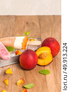 Homemade raspberries and peach popsicles on a wooden table. Стоковое фото, агентство Ingram Publishing / Фотобанк Лори