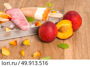 Homemade raspberries and peach popsicles on a wooden table. Стоковое фото, агентство Ingram Publishing / Фотобанк Лори