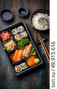 Delicious Sushi Bento Box With Fresh Ingredients Served on Wooden Table. Стоковое AI-изображение, AI-художник Юлия Гапеенко / Фотобанк Лори