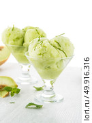 Close up of melon flavored ice-cream with mint and melon on a white table. Стоковое фото, агентство Ingram Publishing / Фотобанк Лори