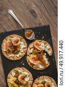 Canape or crostini with multigrain  crispread with cream cheese and fig jam on a slate board. Delicious appetizer ideal as an aperitif. Стоковое фото, агентство Ingram Publishing / Фотобанк Лори