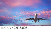 Landing airplane. Landscape with white passenger airplane is flying in the blue sky with pink clouds at sunset. Travel background. Passenger airliner. Business trip. Commercial aircraft. Private jet. Стоковое фото, агентство Ingram Publishing / Фотобанк Лори