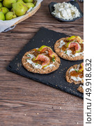 Canape or crostini with multigrain  crispread with cream cheese and fig jam on a slate board. Delicious appetizer ideal as an aperitif. Стоковое фото, агентство Ingram Publishing / Фотобанк Лори
