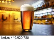 Glass of lager on a wooden table in pab. Стоковое фото, агентство Ingram Publishing / Фотобанк Лори
