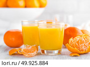 Tangerines, peeled tangerines and tangerine juice in glass. Mandarine juice. Стоковое фото, агентство Ingram Publishing / Фотобанк Лори