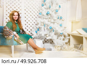 Portrait of a beautiful young brown-haired woman near a Christmas tree. Christmas background. Стоковое фото, агентство Ingram Publishing / Фотобанк Лори