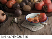 Persimmon fruit on rustic table in vintage style. Стоковое фото, агентство Ingram Publishing / Фотобанк Лори
