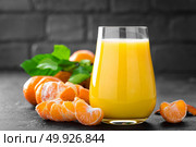 Tangerines, peeled tangerines and tangerine juice in glass. Mandarine juice and fresh fruits with leaves. Стоковое фото, агентство Ingram Publishing / Фотобанк Лори