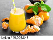 Tangerines, peeled tangerines and tangerine juice in glass. Mandarine juice and fresh fruits with leaves. Стоковое фото, агентство Ingram Publishing / Фотобанк Лори