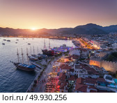 Aerial view of boats and yahts and beautiful architecture at sunset in Marmaris, Turkey. Landscape with boats in marina bay, sea, city, mountains. Top view from drone of harbor with yacht and sailboat. Aerial view of boats and yahts and beautiful architecture at sunset. Стоковое фото, агентство Ingram Publishing / Фотобанк Лори