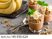 Layered chocolate chia pudding parfait with banana, granola and yogurt, dessert. Стоковое фото, агентство Ingram Publishing / Фотобанк Лори
