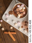 Cups of hot chocolate drink with marshmallows and cinnamon on brown wooden background. Стоковое фото, агентство Ingram Publishing / Фотобанк Лори