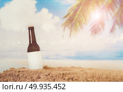 Blank Logo Beer bottle in the sand with beach background. Стоковое фото, агентство Ingram Publishing / Фотобанк Лори