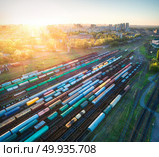 Aerial view of multicolored freight trains. Cargo wagons on railway station. Wagons with goods on railroad. Heavy industry. Industrial landscape with train, railway platfform at sunset. Top view.Depot. Aerial view of colorful freight trains on railroad. Стоковое фото, агентство Ingram Publishing / Фотобанк Лори
