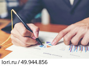 Close up hands signing terms of agreement documents of businessman on his desk, business signing concept. Стоковое фото, агентство Ingram Publishing / Фотобанк Лори