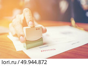 Close-up hand stamping of businessman for signing approval on documents , business concept. Стоковое фото, агентство Ingram Publishing / Фотобанк Лори