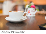 Cup of cappuccino at coffee shop background. . Стоковое фото, агентство Ingram Publishing / Фотобанк Лори