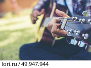 Close up of young hipster man practiced guitar in the park,happy. Close up of young hipster man practiced guitar in the park,happy and enjoy playing guitar. Стоковое фото, агентство Ingram Publishing / Фотобанк Лори