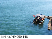 A boat approaching Mon bridge in Sangkhlaburi , Thailand. Стоковое фото, агентство Ingram Publishing / Фотобанк Лори
