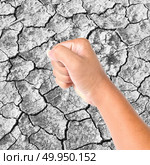 Clenched a fist on dry cracked soil. Стоковое фото, агентство Ingram Publishing / Фотобанк Лори