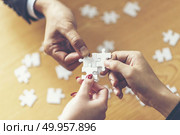 Business solutions, success and strategy concept. Businessman ha. Business solutions, success and strategy concept. Businessman hand connecting jigsaw puzzle.. Business solutions, success and strategy concept. Businessman hand connecting jigsaw puzzle. Стоковое фото, агентство Ingram Publishing / Фотобанк Лори