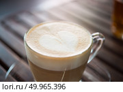 Close up of cappuccino cup with heart shaped milk pattern at caf. Close up of cappuccino cup with heart shaped milk pattern at cafe. a cup of coffee art. Стоковое фото, агентство Ingram Publishing / Фотобанк Лори