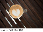 Close up of cappuccino cup with heart shaped milk pattern at caf. Close up of cappuccino cup with heart shaped milk pattern at cafe. a cup of coffee art. Стоковое фото, агентство Ingram Publishing / Фотобанк Лори