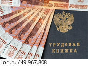Трудовая книжка окружена деньгами номиналом пять тысяч рублей. Стоковое фото, фотограф Евгения Золкина / Фотобанк Лори