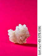 Crystals of sweet sugar on a pink pantone paper for tea, place under text.. Big piece of natural sweet isolated on a rad backgrond. Стоковое фото, агентство Ingram Publishing / Фотобанк Лори