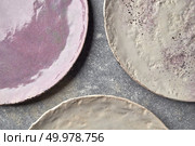 Decorative clay plates covered with glazed on a gray background with place for text. Traditional decorative ceramic handcrafted. Flat lay. The porcelain vintage plates handmade on a gray marble table. Стоковое фото, агентство Ingram Publishing / Фотобанк Лори