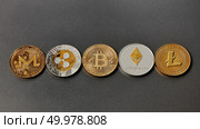 Set of gold and silver coins monero, ripple, bitcoin, litecoin, ethereum, dash on a black background. Conceptual image for worldwide cryptocurrency and digital payment system. Top view. Five different coins of crypto-currencies presented in a row on a dark background. Virtual money concept. Top view. Стоковое фото, агентство Ingram Publishing / Фотобанк Лори