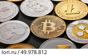 A pattern from different coins of crypto currency on a dark background. Gold and silver coins ripple, bitcoin, litecoin, ethereum, dash. Business concept. Top view. Close-up of shiny gold and silver coins on a dark background. Business and technology concept. Top view. Стоковое фото, агентство Ingram Publishing / Фотобанк Лори