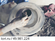 The woman’s hands close up, the masterful studio of ceramics works with clay on a potter’s wheel. Стоковое фото, агентство Ingram Publishing / Фотобанк Лори