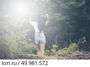Young woman with windy messy hair backlit by sun selective focus toned image, sun flares. Стоковое фото, агентство Ingram Publishing / Фотобанк Лори