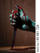 Closeup, Ghost woman or zombie hold knife for kill with blood violence in house of ruin, nightmare, horror of scary fear on hell is monster devil in halloween festival. Стоковое фото, агентство Ingram Publishing / Фотобанк Лори