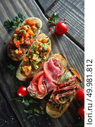 Delicious Canapes.Assorted Italian appetizer bruschetta with chopped vegetables, salmon and meat on ciabatta bread, garnished with green mix salad. Assorted Italian appetizer bruschetta. Стоковое фото, агентство Ingram Publishing / Фотобанк Лори