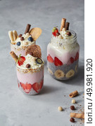 Healthy summer breakfast idea, homemade layered parfe dessert in jar with chia, yoghurt and berries on a stone background. Copy space. Colorful layered smoothie with berries, biscuits and whipped cream in jar on a stone background. Стоковое фото, агентство Ingram Publishing / Фотобанк Лори