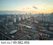 Kiev, Ukraine.- January 11,2018: View from a birdseye on the city of Kiev, modern high-rise buildings and a small church, a photo taken from a drone. Aerial view of the city of Kiev in the morning, Редакционное фото, агентство Ingram Publishing / Фотобанк Лори