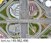 Aerial view district Poznyaki, road junction with passing cars, parking, green area and buildings in sity Kiev, Ukraine. Photo from the drone. Aerial view road junction, in the form of a quatrefoil Poznyaki district, Kiev. Стоковое фото, агентство Ingram Publishing / Фотобанк Лори