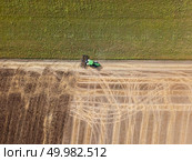 Cultivation of the agricultural field after harvesting. Preparation of soil for sowing of winter crops. Aerial view from the drone of the field after harvest.. Panoramic view of tractor plowing the soil after harvesting on the field. Top view from drone. Стоковое фото, агентство Ingram Publishing / Фотобанк Лори