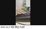 The woman holds a plastic bank card with one hand and types a code on the computer keyboard with the other. Close-up. Стоковое видео, видеограф Ярославский Максим / Фотобанк Лори