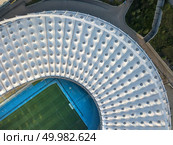 KIEV, UKRAINE - July 19, 2018. Panoramic view from drone of the National Sports Complex Olimpiysky at summer sunset - the stadium cover structure. Abstract architecture photo. Construction of the stadium roof, firld and tribunes.. KYIV, UKRAINE - July 19, 2018. NSC Olimpiysky the birds eye view from drone of construction the stadium roof, green football field, tribunes of complex. Редакционное фото, агентство Ingram Publishing / Фотобанк Лори