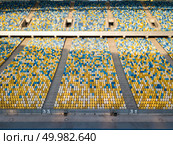 KIEV, UKRAINE - July 19, 2018. Panoramic view from drone on empty even rows tribunes of National Sports Complex Olimpiysky in a blue and yellow colors in the summer time.. KYIV, UKRAINE - July 19, 2018. Empty tribunes of NSC Olimpiysky before the soccer game. Редакционное фото, агентство Ingram Publishing / Фотобанк Лори