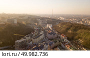 Aerial view from the drone, bird’s eye view to the Vozdvizhenka with newly built buildings, Andreevsky descent, tower Kyiv TV Center and other old houses.. A bird’s eye view, aerial view shooting from drone of the Podol district, oldest historical center of Kiev, Ukraine. Стоковое фото, агентство Ingram Publishing / Фотобанк Лори