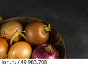 Fresh whole onions in assorted colors and parsley in a small rustic frying pan on kitchen counter top. Стоковое фото, агентство Ingram Publishing / Фотобанк Лори