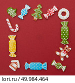 Frame of Christmas cookies of different shapes and colors on a red background. Frame of Christmas cookies. Стоковое фото, агентство Ingram Publishing / Фотобанк Лори