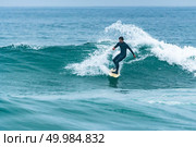 Surfer in action on the ocean waves on a cloudy day. Стоковое фото, агентство Ingram Publishing / Фотобанк Лори