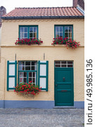Brugge, Belgium. Old town building with door and flowers in windows.. Old town building with door and flowers in windows. Стоковое фото, агентство Ingram Publishing / Фотобанк Лори