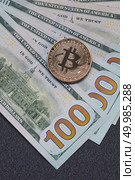 Gold coin bitcoin and new hundred dollar bills. Exchange of Crypto-Currency for Dollars. Conceptual image for worldwide cryptocurrency and digital payment system.. Gold coin bitcoin and new hundred dollar bills. Exchange of Crypto-Currency for Dollars. Стоковое фото, агентство Ingram Publishing / Фотобанк Лори